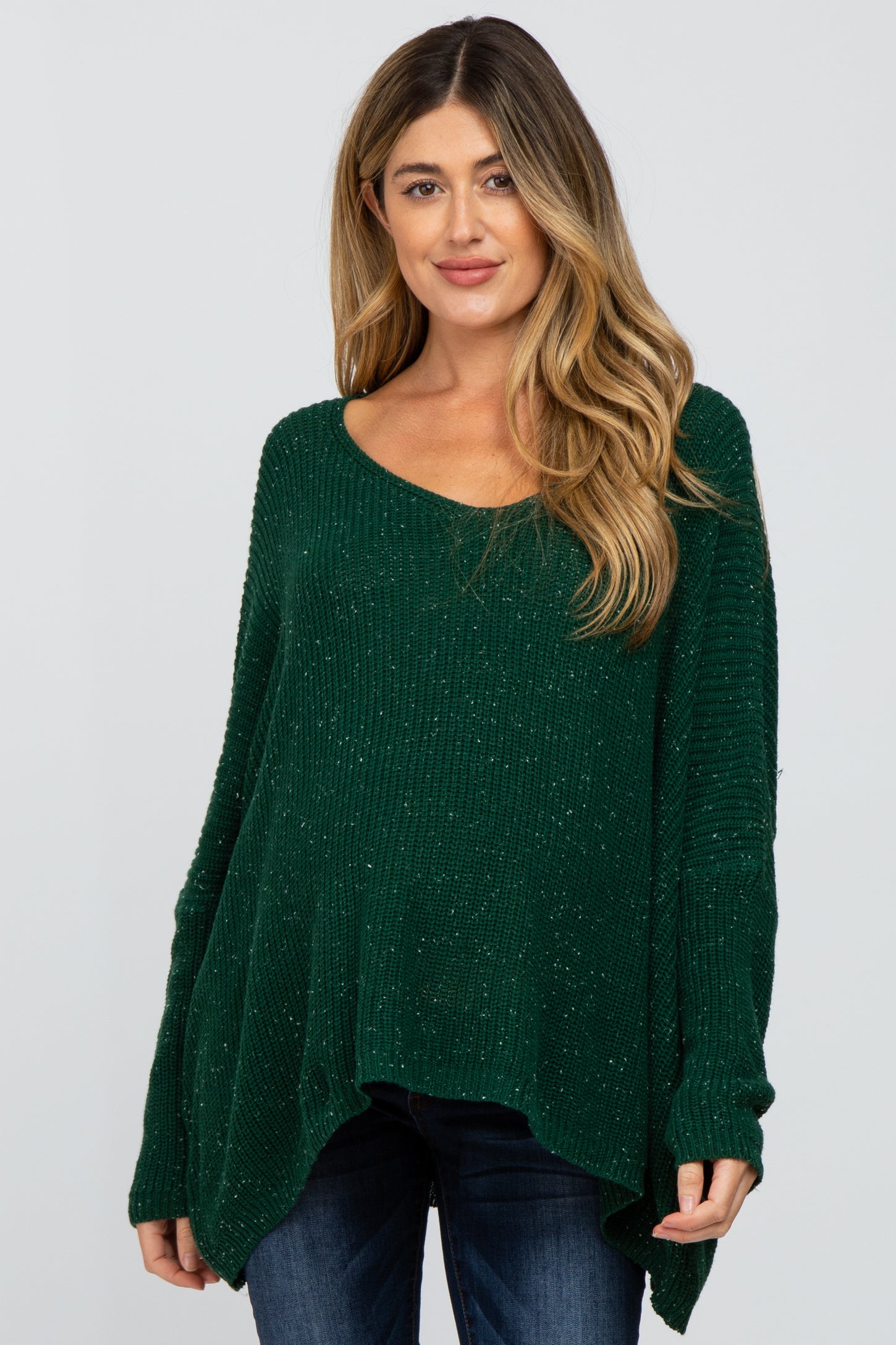 woman wearing a dark green sparkly maternity sweater with a relaxed fit and wide sleeves
