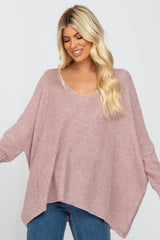 woman wearing a soft pink oversized knit sweater with a v-neck and wide sleeves