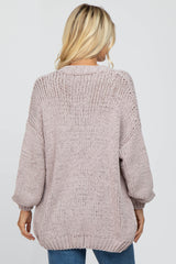 woman wearing a light pink oversized knit sweater with a relaxed fit and long sleeves, view from the back