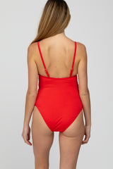 woman wearing a red maternity swimsuit with adjustable straps, showing the back view