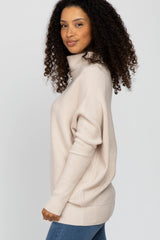 woman wearing a light beige turtleneck sweater with a relaxed fit and side slits, standing sideways