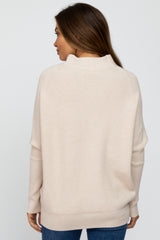 woman wearing a beige maternity sweater with a relaxed fit and ribbed texture, viewed from the back