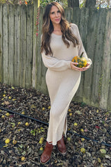 woman wearing a beige ribbed knit maxi dress and holding a small pumpkin in an outdoor setting