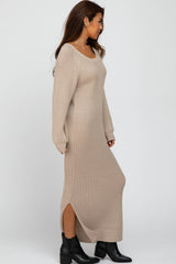 woman wearing a beige ribbed maxi dress with long sleeves and side slits, paired with black ankle boots