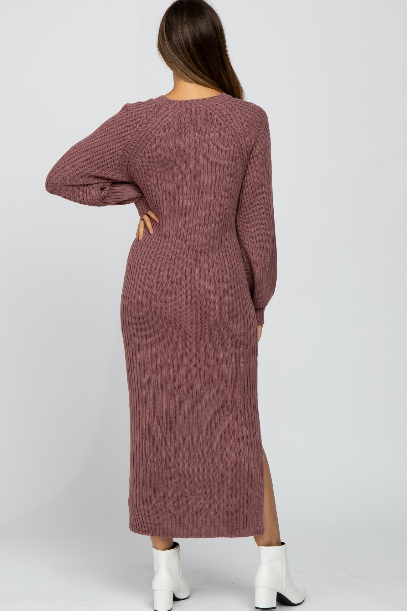 woman wearing a mauve long sleeve ribbed maternity dress with a side slit and fitted silhouette