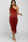 woman wearing a rust one-shoulder maternity dress with ruching and a visible baby bump