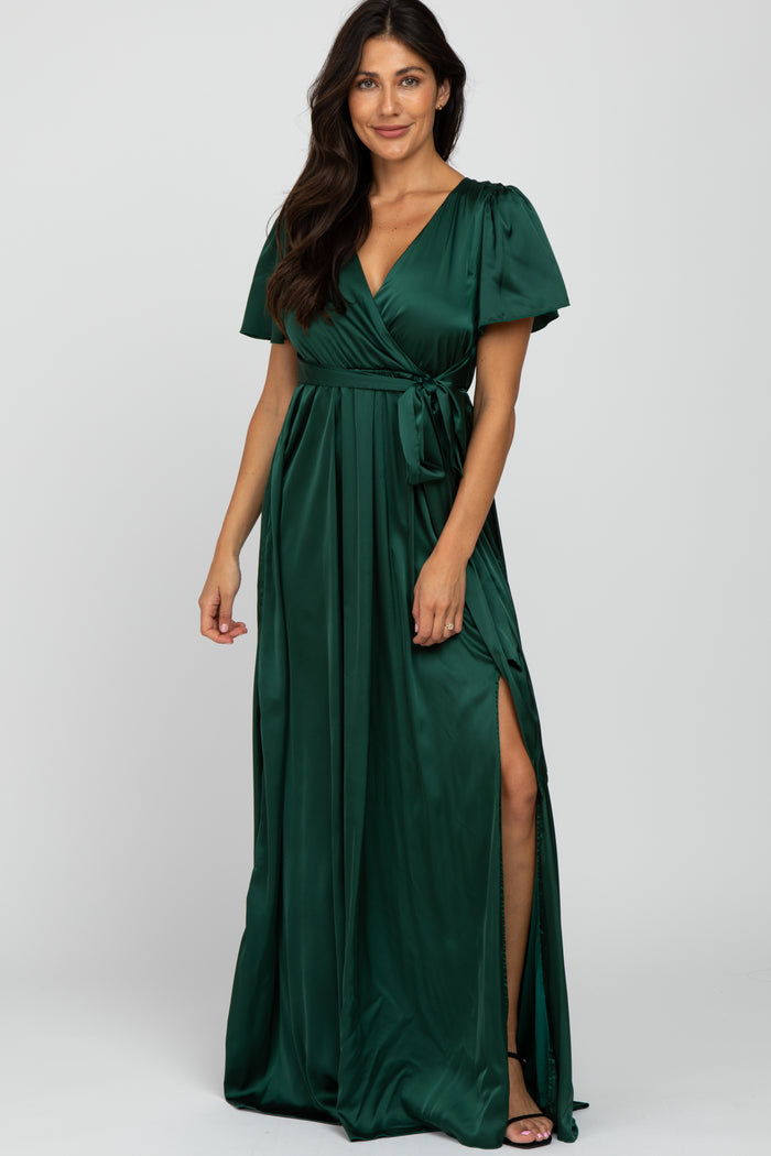 woman wearing a dark green wrap maxi dress with short puff sleeves and a side slit