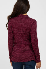 woman wearing a burgundy long sleeve top with a textured finish and gathered back detail