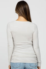 woman wearing a light grey long sleeve maternity top with ruching at the sides, view from the back