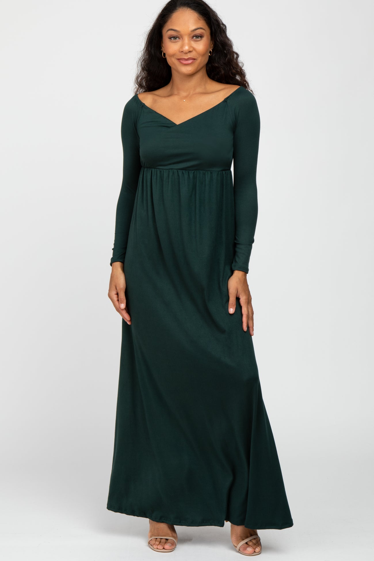 woman wearing a dark green long sleeve maxi dress with a sweetheart neckline and fitted bodice