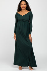 woman wearing a dark green long sleeve maxi dress with a sweetheart neckline and fitted bodice