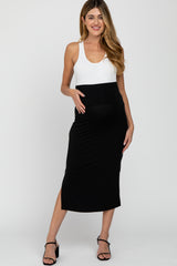woman wearing a black and white maternity dress with a fitted bodycon style and a visible baby bump