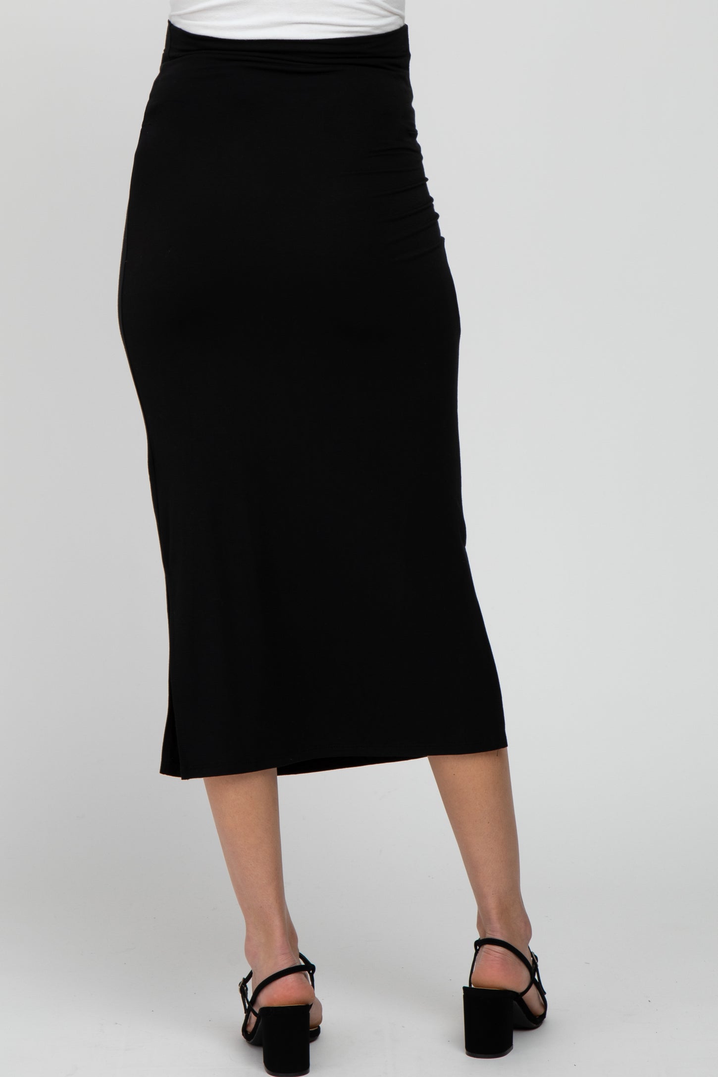 woman wearing a black maternity midi skirt, showing the back view with a side slit and a fitted silhouette