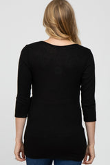 woman wearing a black maternity top with three-quarter sleeves, viewed from the back