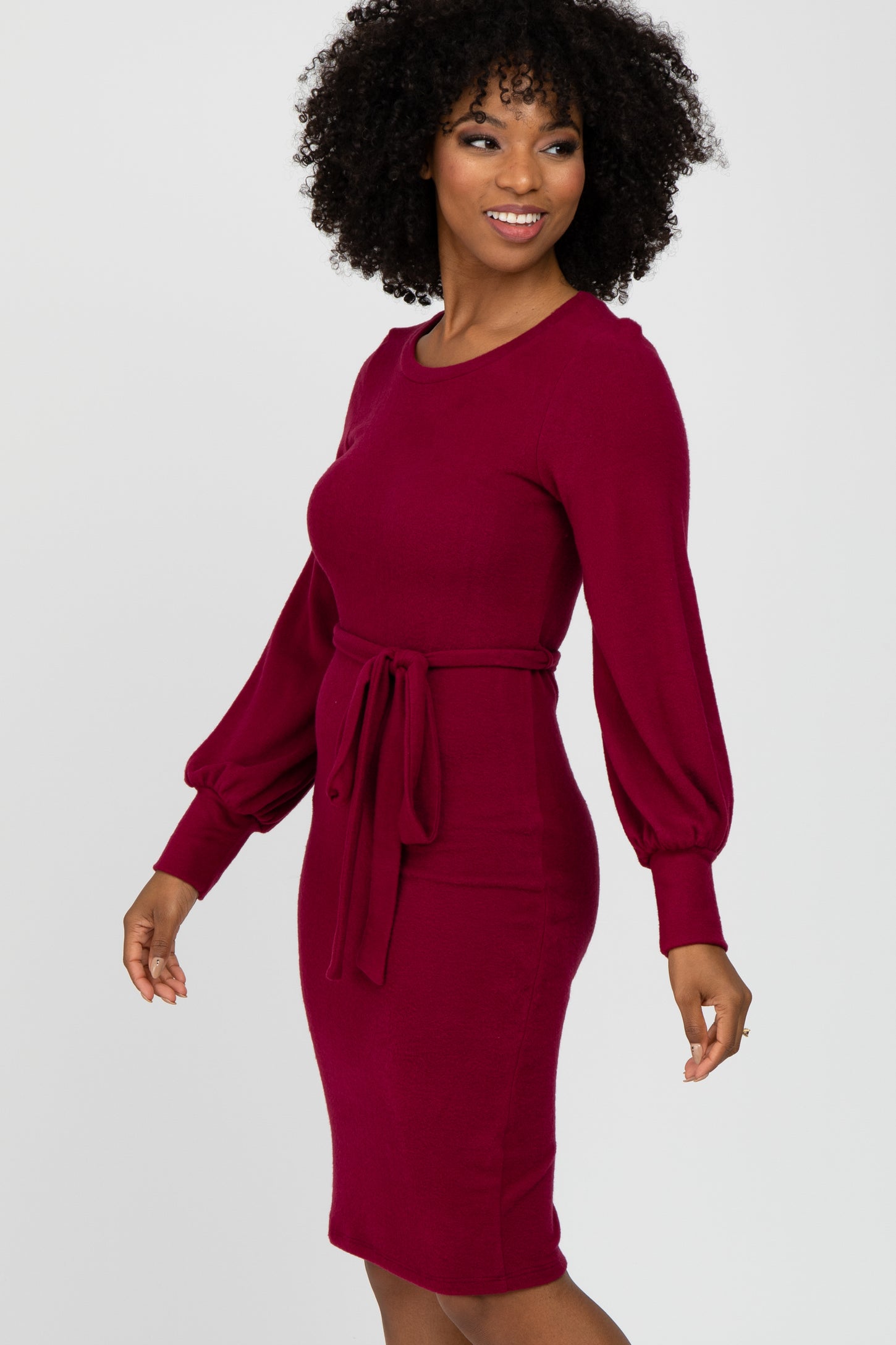 woman wearing a maroon long sleeve dress with a belted waist and balloon sleeves