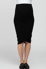 woman wearing a black maternity skirt with gathered details on the sides and a fitted silhouette showcasing her baby bump