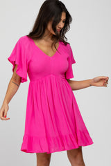 woman wearing a bright pink short sleeve dress with a v-neckline and flared ruffle hem