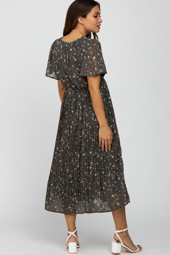 woman wearing a dark gray floral maternity dress with short sleeves and pleated skirt, showing a baby bump from the side