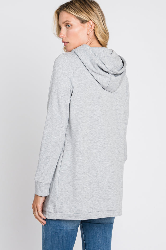 woman wearing a gray long sleeve hooded sweatshirt with a relaxed fit and side slit details