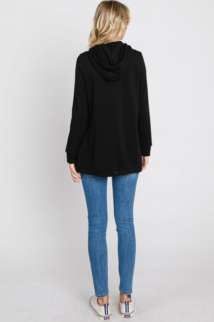 woman wearing a black long sleeve hoodie and blue skinny jeans, shown from the back