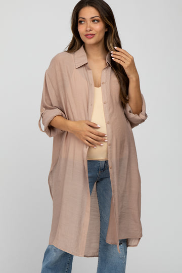 woman wearing a light brown maternity shirt dress with rolled sleeves and a visible baby bump