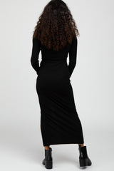 woman wearing a fitted black long sleeve maxi dress, showing the back view, styled with black ankle boots