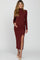 woman wearing a burgundy long sleeve maternity dress with a side slit and holding her baby bump