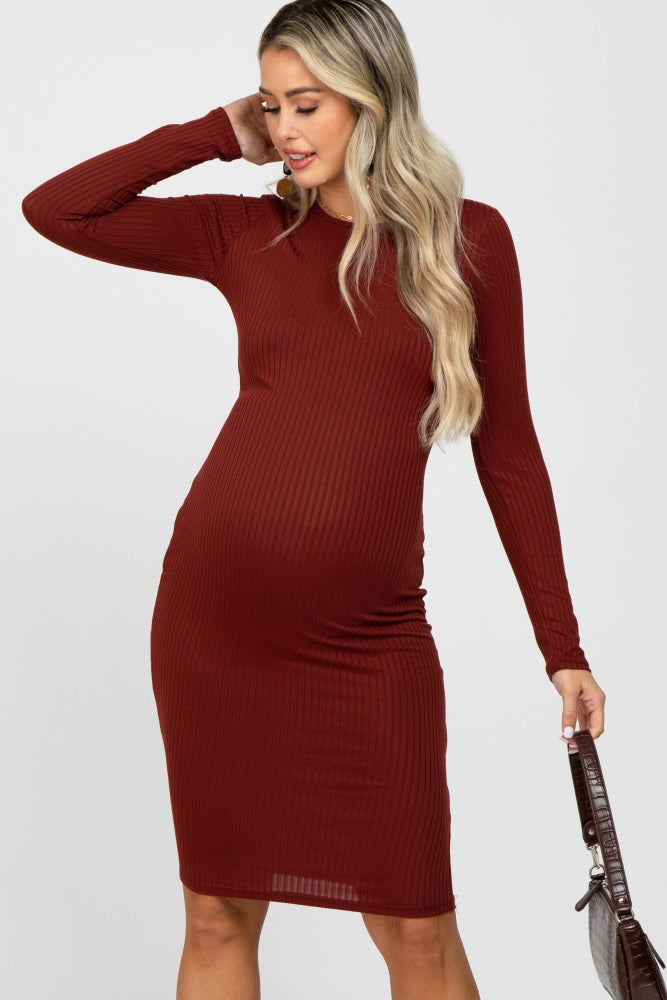 woman wearing a burgundy long sleeve ribbed maternity dress and showcasing her baby bump