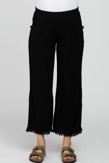woman wearing black maternity wide-leg pants with fringe hem and side pockets
