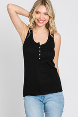 woman wearing a black sleeveless henley tank top with buttons and light blue jeans