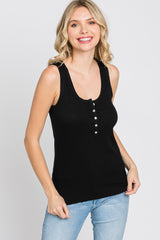 woman wearing a black ribbed tank top with button detail, paired with light blue jeans