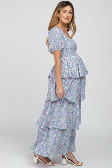 Pregnant woman in a tiered purple floral maternity maxi dress with puff sleeves and smocked bodice