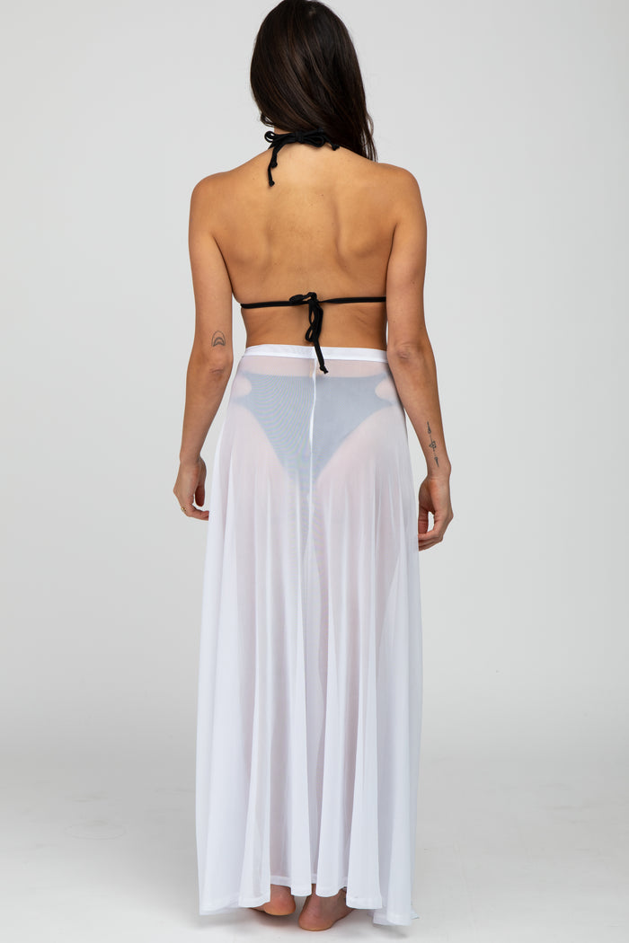 woman wearing a black bikini top and a sheer white long skirt, viewed from the back