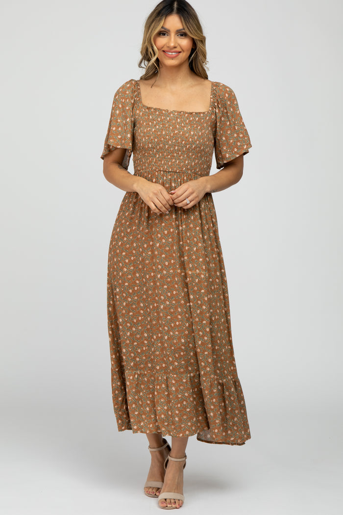 woman wearing a brown floral smocked midi dress with flutter sleeves and square neckline