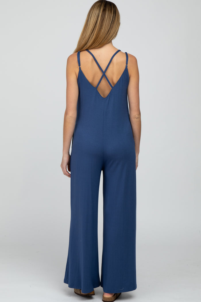 woman wearing a navy blue maternity jumpsuit with crisscross straps on the back