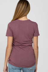 woman wearing a mauve short sleeve maternity top with a fitted style, showing the back view