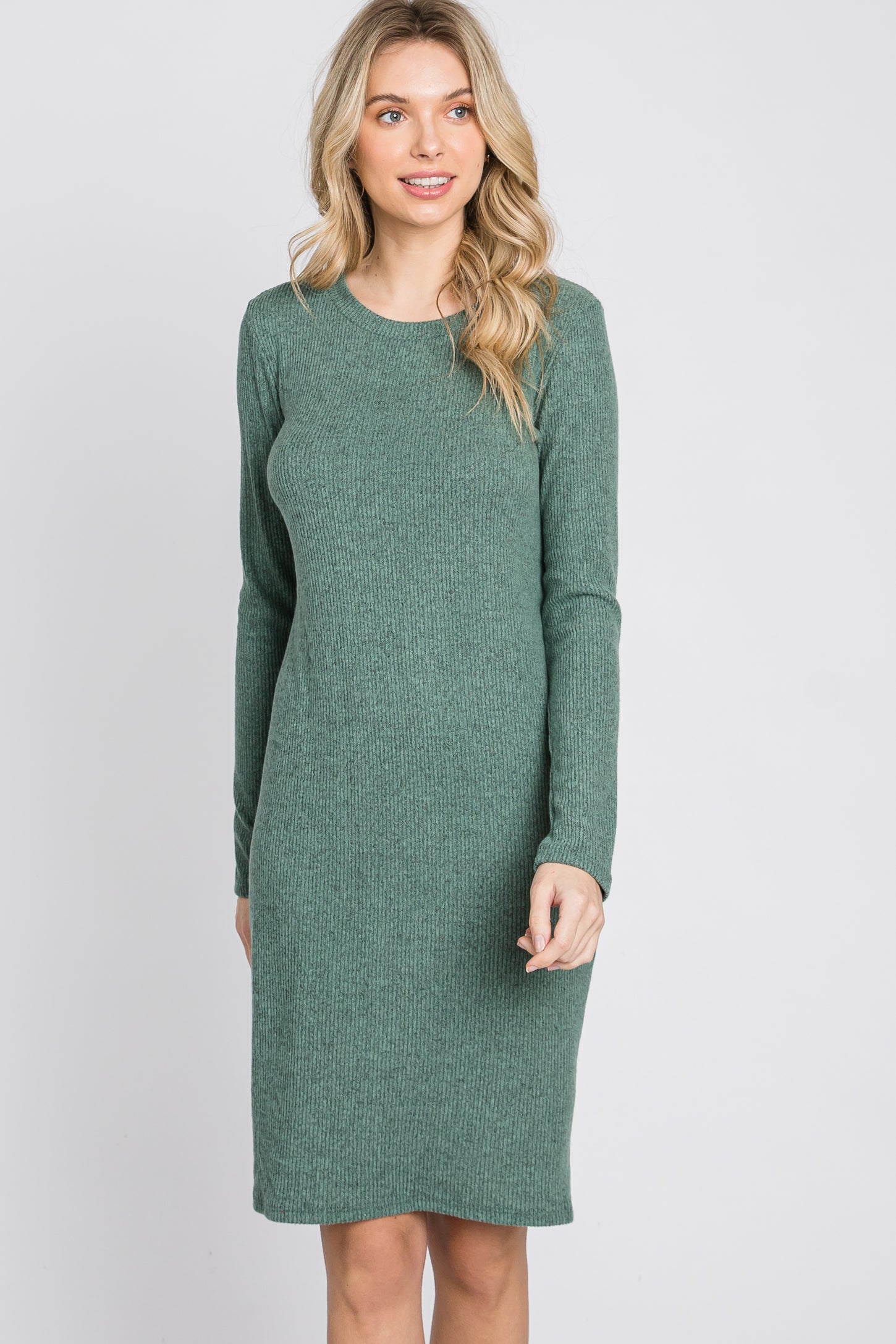 woman wearing a green ribbed long sleeve sweater dress with a relaxed fit