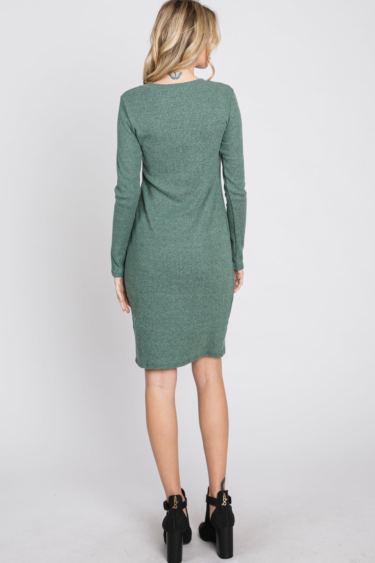 woman wearing a green sweater dress with long sleeves and a fitted silhouette, seen from the back