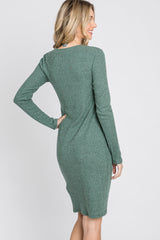 woman wearing a green ribbed long sleeve sweater dress, showing the back view with a fitted style