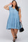 Woman in a light blue tiered denim dress with ruffle sleeves, black sandals, and a black handbag.