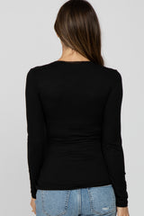 woman wearing a fitted black long sleeve maternity top, viewed from the back