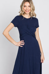 woman wearing a navy blue short sleeve maxi dress with a twisted front detail