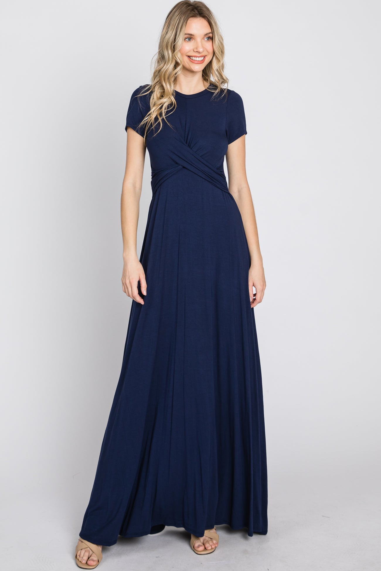 woman wearing a navy blue short sleeve maxi dress with a wrap front and flowing skirt
