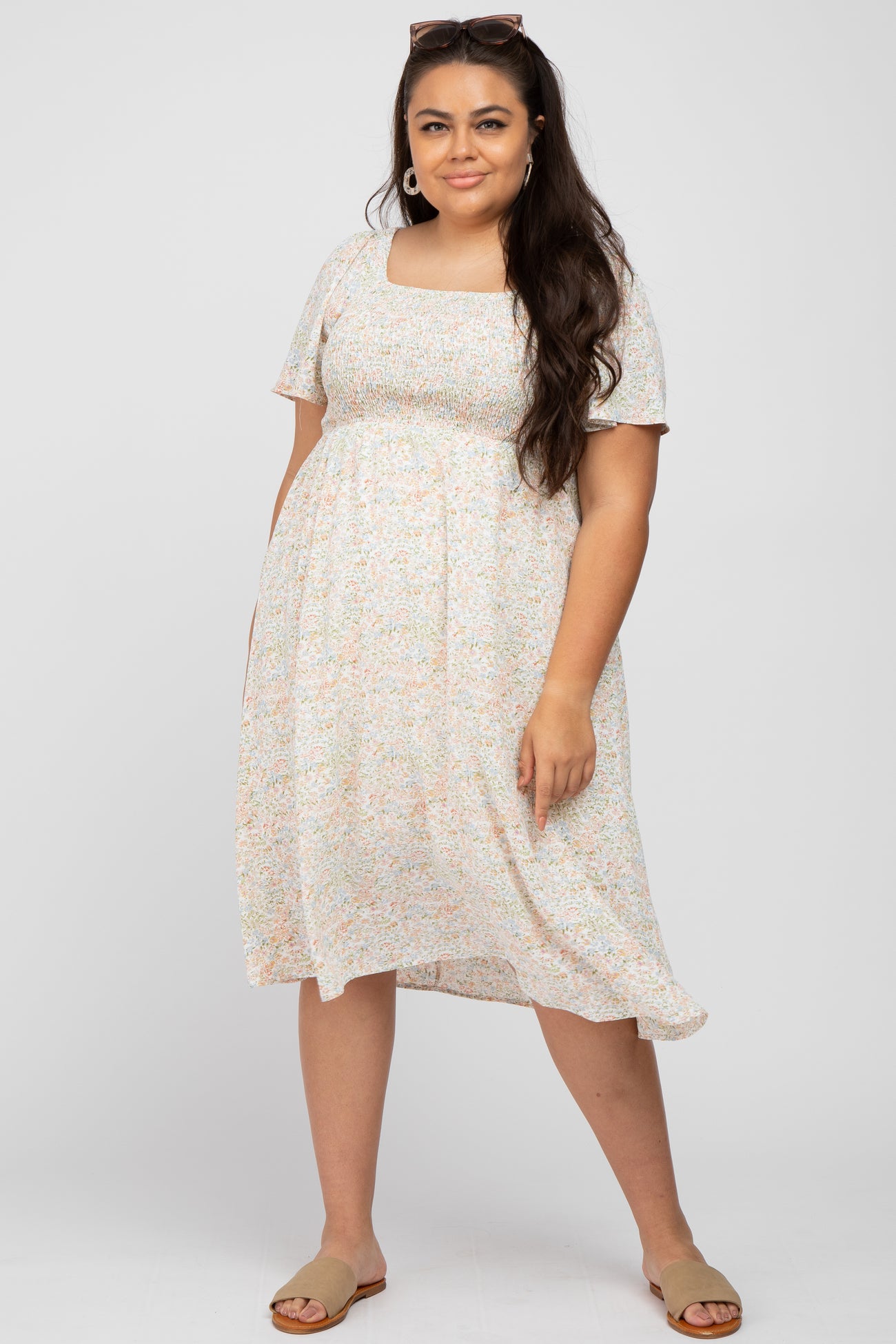 woman wearing a short sleeve floral print plus size dress with a square neckline and flowy hem