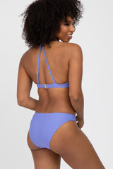 woman wearing a lavender bikini with a halter neck top and matching bikini bottom, viewed from the back