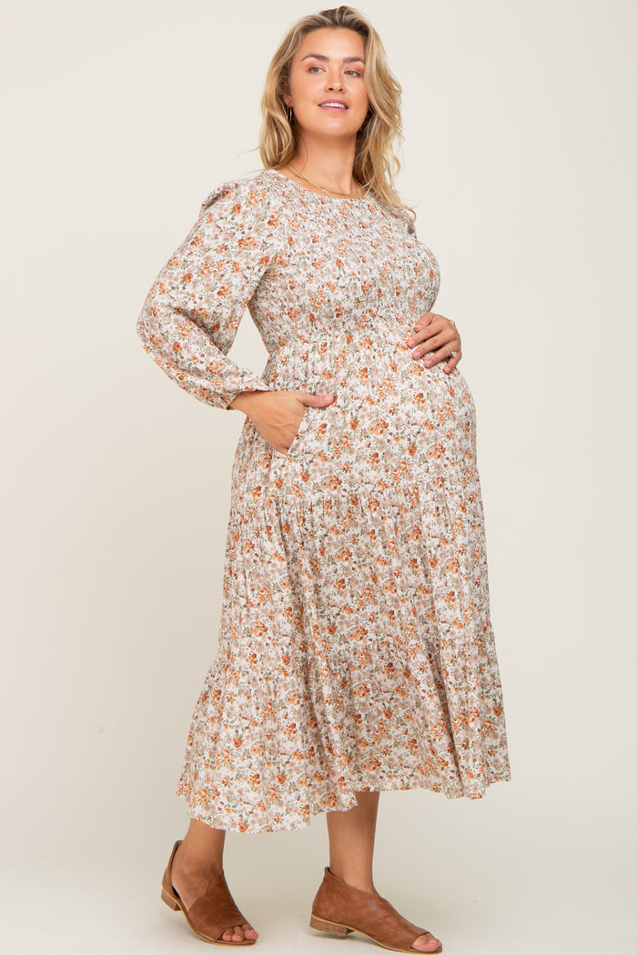 woman wearing a floral long sleeve maternity dress with pockets and showing her baby bump
