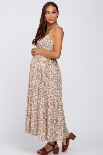 woman wearing a floral maternity maxi dress with adjustable straps and a visible baby bump