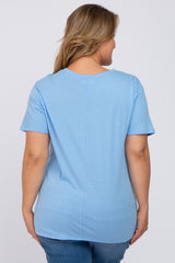 woman wearing a light blue short sleeve maternity top, viewed from the back, paired with blue jeans