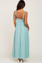 back view of a woman wearing a light blue maxi dress with adjustable straps and a smocked waist