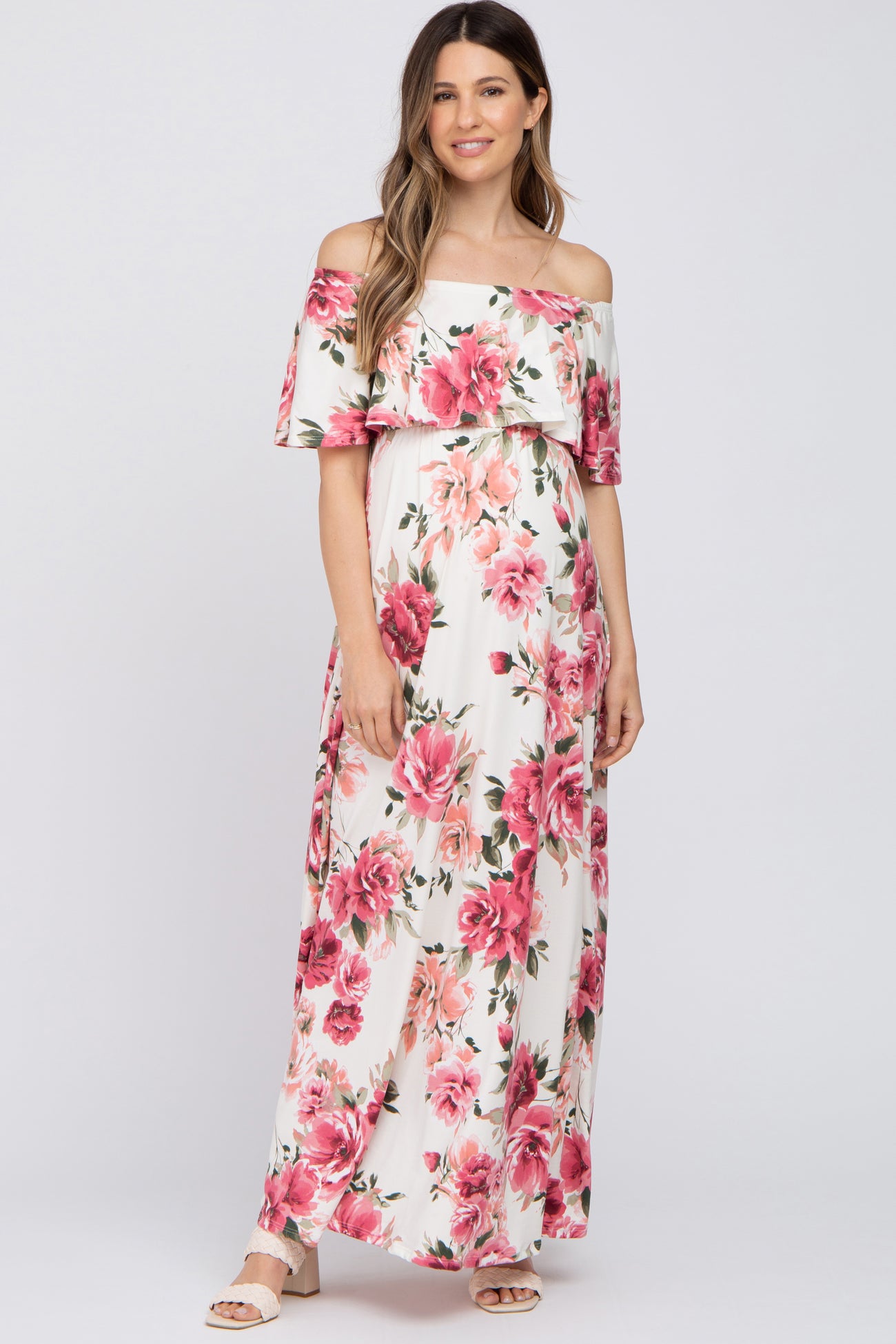 woman wearing a floral off-shoulder maxi dress, showcasing her baby bump in this maternity wear